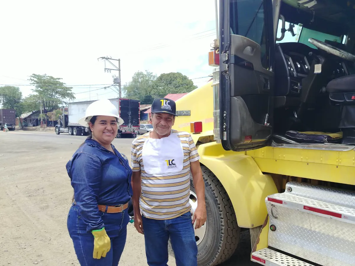 Colaboradores de TLC junto a un tractocamión de la empresa